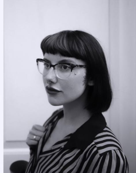 Scarlett's headshot is of her with a black bob and glasses, looking to the left